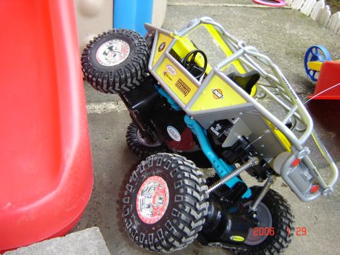 1993 Ford Bronco - This remote control rock crawler toy is shown tipped over next to a red plastic slide.
