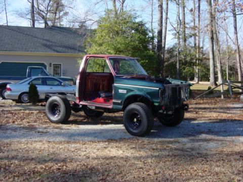 1991 Ford Bronco - Red and grey cab, green fenders, grey core support. Once the crossmember is done and the seats are adapted in, it will all come back apart…