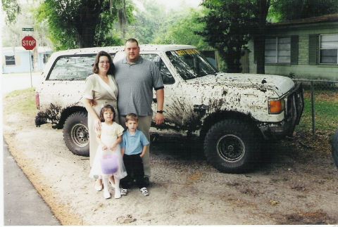 1989 Ford Bronco - A family poses with their mud-covered SUV, which appears to be from the late 1980s.