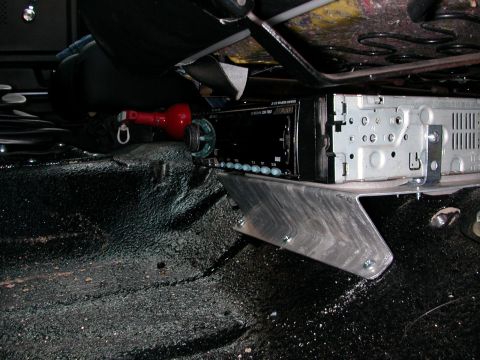1984 Ford Bronco - Aftermarket car stereo installed beneath the seat, accompanied by a red fire extinguisher.