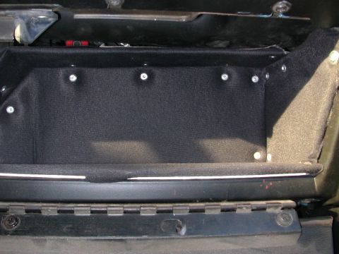 1984 Ford Bronco - Interior compartment lined with black fabric and secured with screws.