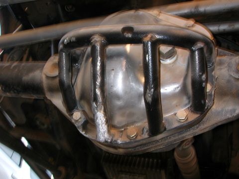 1984 Ford Bronco - Close-up of a vehicle's rear differential housing, protected by a metal cage.