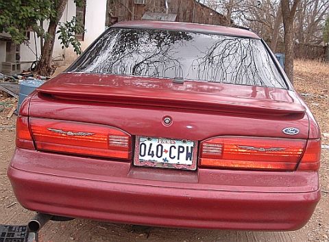 1994 Ford Thunderbird - Rear view of a red 1994 Ford Thunderbird, showing its distinctive taillights and spoiler.