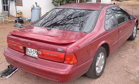 1994 Ford Thunderbird - The rear view of a red 1994 Ford Thunderbird coupe shows its distinctive taillights and spoiler.