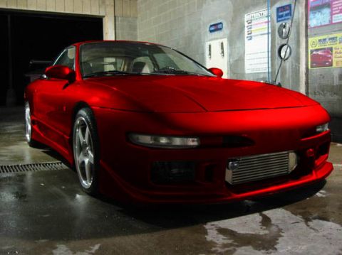 1994 Ford Probe - A red 1994 Ford Probe is shown from the front-three-quarter view, possibly at a car wash.