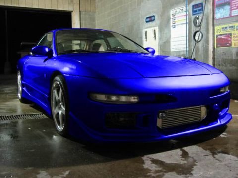1994 Ford Probe - A bright blue sports coupe is parked in a car wash bay, showing off its custom front bumper and intercooler.