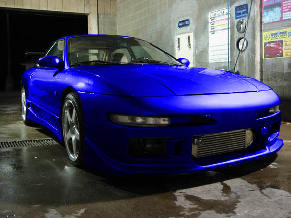 blue sports coupe with aftermarket intercooler in a car wash bay