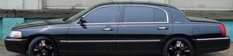 1999 Ford Crown Victoria - This black sedan features tinted windows and chrome accents along its side.