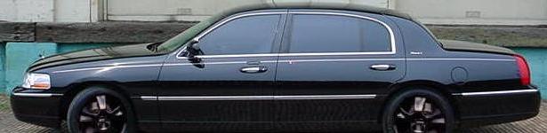Side view of black sedan with tinted windows and chrome trim