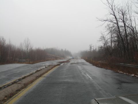1995 Ford Bronco - The road ahead is obscured by fog, with visible damage and debris.