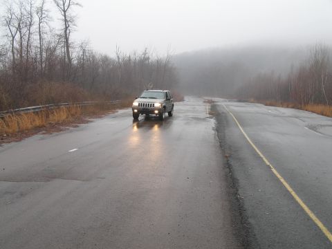 1995 Ford Bronco - Jeep Grand Cherokee on a wet, foggy road.