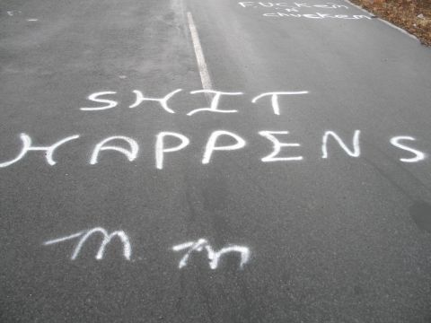 1995 Ford Bronco - White chalk graffiti is spray-painted on a paved surface, with a white line dividing the lane.