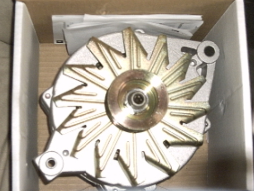 Alternator part in a cardboard box, top view