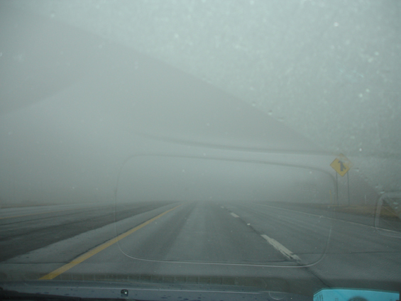 Foggy multi-lane road seen through a windshield