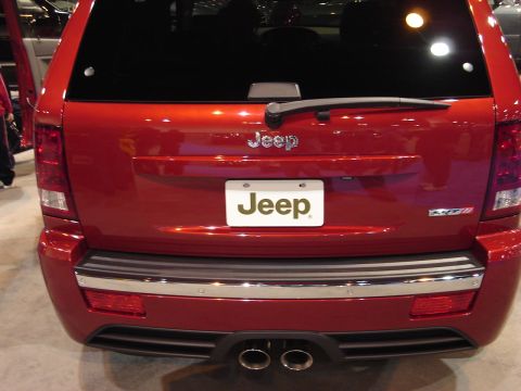 2000 Ford Crown Victoria - The rear of a red Jeep Grand Cherokee SRT8 is shown, chrome accents and dual exhaust pipes.