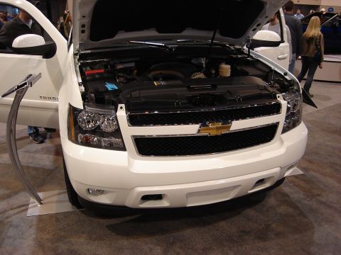 2000 Ford Crown Victoria - A white Chevrolet SUV is displayed with its hood open, revealing the engine compartment.