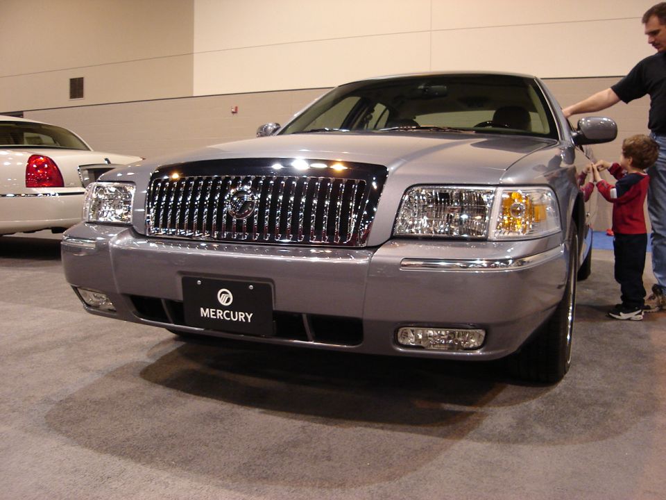 Silver Mercury Grand Marquis with chrome grille and Mercury badge, front view