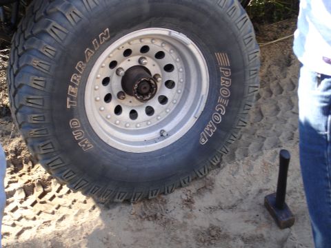 1989 Ford Bronco - A close-up view of an off-road tire and wheel assembly, with text indicating it's a Pro Comp Mud Terrain tire.