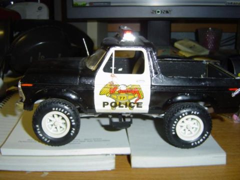 1979 Ford Bronco - A toy police car is displayed on a stack of books.