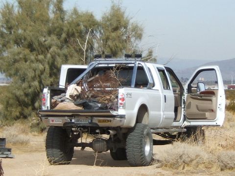 1988 Ford Bronco - Pickup truck loaded with debris in a dry, outdoor setting. License plate reads 6N56333.