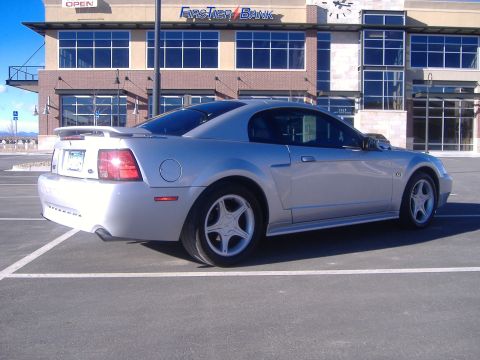 2003 Ford Mustang - Silver 2003 Ford Mustang GT parked in a lot, showing its rear quarter profile.