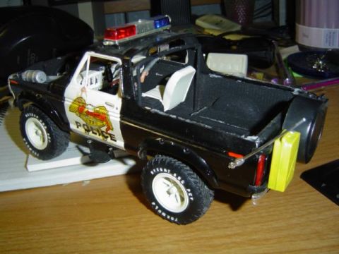 1979 Ford Bronco - Model of a 1979 Ford Bronco police truck with "POLICE" markings and emergency lights.