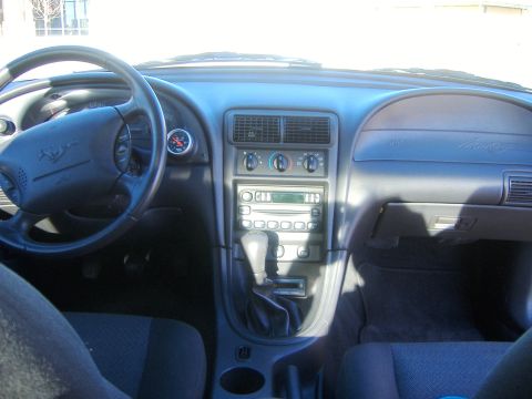 2003 Ford Mustang - The dashboard and interior of a 2003 Ford Mustang are visible, including the steering wheel and radio.