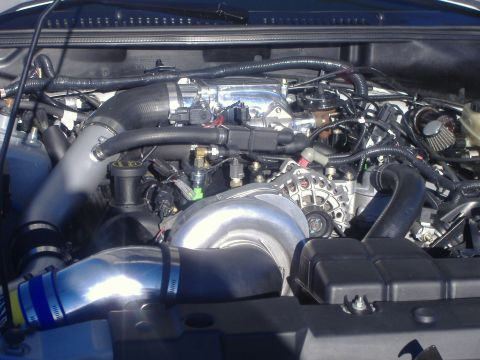 2003 Ford Mustang - Close-up view of the engine bay in a 2003 Ford Mustang, highlighting the turbocharger and intake system.