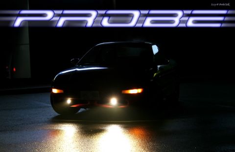 1994 Ford Probe - A 1994 Ford Probe is shown from the front at night with its headlights illuminated on wet pavement.