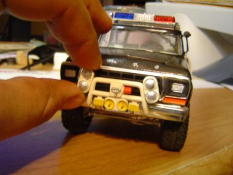 1979 Ford Bronco - Model of a 1979 Ford Bronco police vehicle is held by fingers.