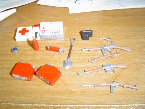 1979 Ford Bronco - Collection of toy military accessories including firearms, fuel cans, and a first aid kit.