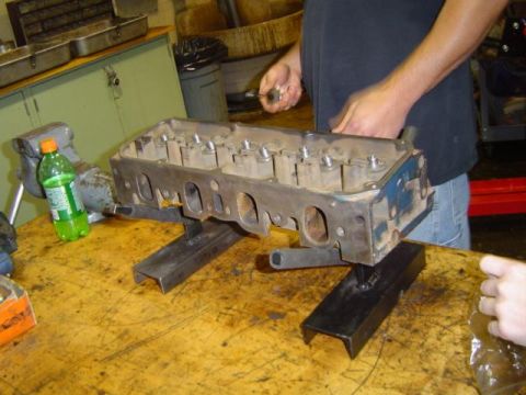 1979 Ford Bronco - A close-up view of an engine cylinder head being serviced on a workbench.