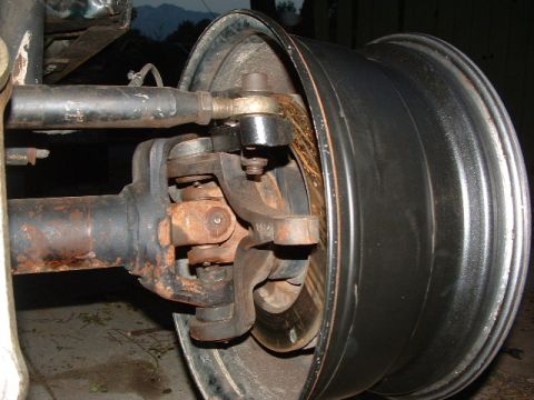 1994 Jeep YJ - This photo shows the front axle, U-joint, and wheel of a Jeep, likely undergoing maintenance or repair.