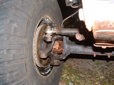 1994 Jeep YJ - Close-up view of the front wheel and suspension system, showing the tire, brake rotor, and steering components.