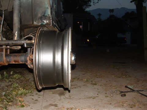 1994 Jeep YJ - Close-up of a Jeep YJ wheel and axle assembly, with part of the vehicle body visible.