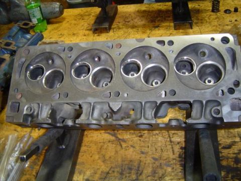 1979 Ford Bronco - A close-up view of a disassembled engine cylinder head, showing the intake and exhaust ports.