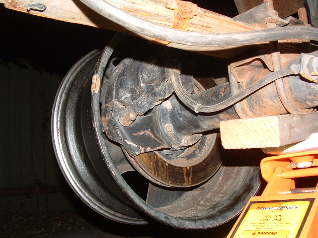 close-up of vehicle's rear axle, brake drum, and leaf spring assembly