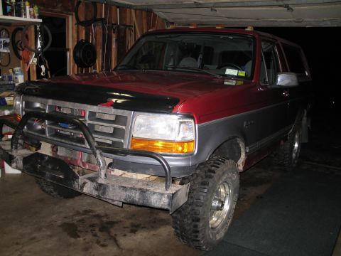 1995 Ford Bronco - The front of a 1995 Ford Bronco is visible, a two-tone paint job and an aftermarket bumper.