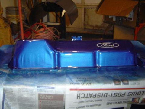 1979 Ford Bronco - A Ford valve cover, painted in metallic blue and purple, sits on a surface covered with newspapers.