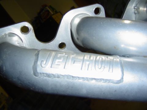 1979 Ford Bronco - Close-up of a metal exhaust manifold with "JET-HOT" branding visible.
