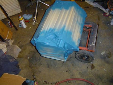 1979 Ford Bronco - Engine block on a dolly, partially painted blue and tan.