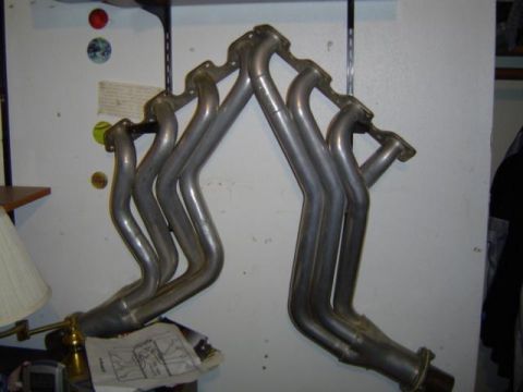 1979 Ford Bronco - Exhaust headers are shown mounted on a wall, with a diagram and lamp in the foreground.