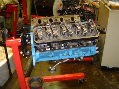 1979 Ford Bronco - Engine block assembly with valve train components visible, mounted on a red engine stand in a workshop.