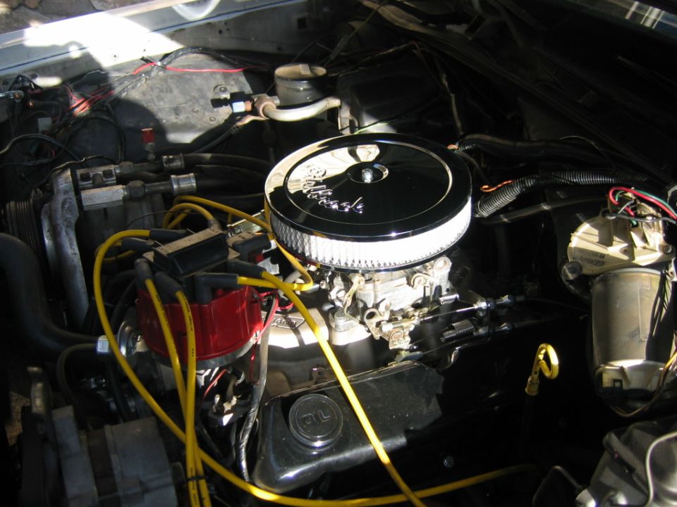 Engine bay showing a V8 engine with a chrome air cleaner and red distributor cap