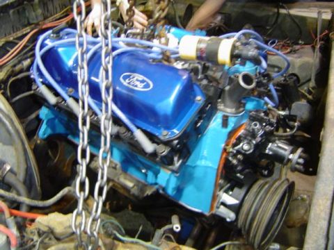 1979 Ford Bronco - A Ford V8 engine, possibly undergoing a rebuild, is suspended by chains within an engine bay.