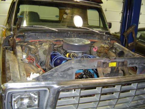 1979 Ford Bronco - The engine bay of a Ford truck is shown with the hood open, revealing the V8 engine and various components.