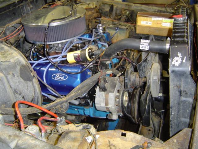 Ford V8 engine with blue valve covers, air filter, radiator, and alternator visible