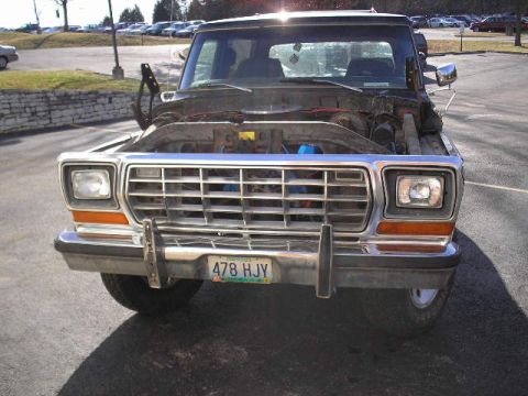 1979 Ford Bronco - The front of a 1979 Ford Bronco is shown with its hood raised, revealing the engine compartment.