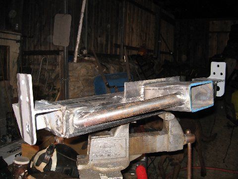 1988 Ford Bronco - A metal fabrication part is secured in a vise, undergoing modification in a workshop setting.