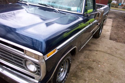 1975 Ford F-150 - This 1975 Ford F-150 pickup truck is shown from a 3/4 front angle, highlighting its dark blue paint.